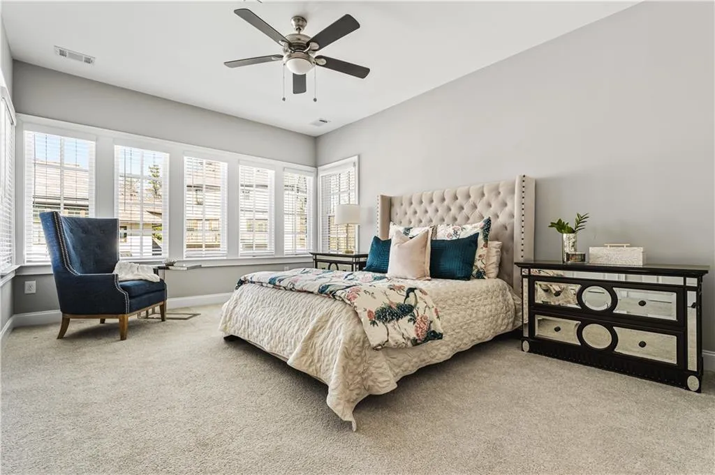 Bedroom featuring baseboards, visible vents, ceiling fan, and carpet flooring