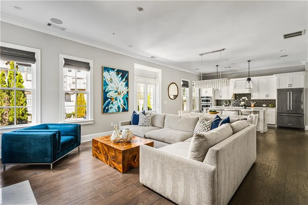 Living area featuring plenty of natural light, dark wood finished floors, visible vents, and crown molding