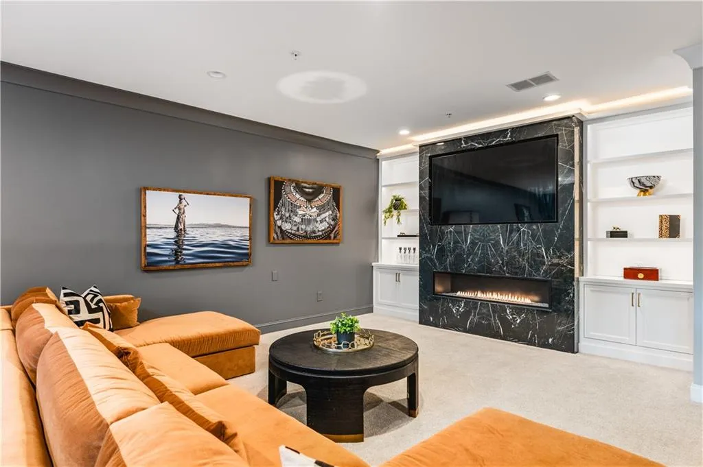 Living room featuring built in features, carpet, visible vents, and a fireplace