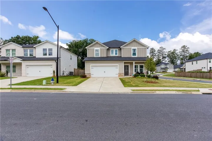 Two-story residence with a two-car garage, manicured lawn, and a paved driveway