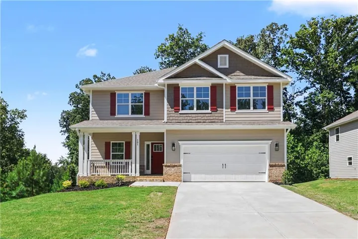 Two-story residence featuring a covered front porch, an attached two-car garage, and a concrete driveway