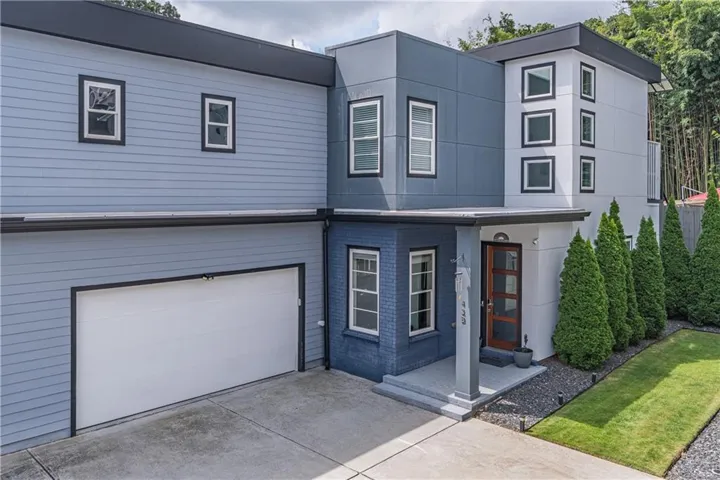 Modern two-story residence featuring a striking mixed-material exterior with light blue and dark blue horizontal siding, complemented by white trim and multi-pane windows