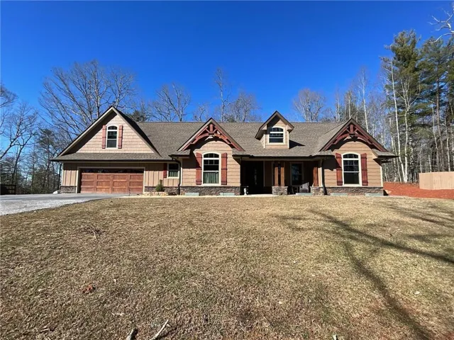 Craftsman inspired home with a porch, driveway, a garage, a front yard, and roof with shingles