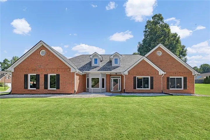 Brick exterior with white trim, multiple gables, bay windows, and a dormer