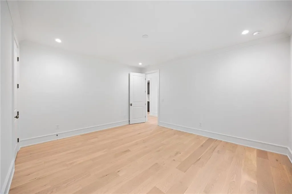 Recessed lighting, wood-finish flooring, white walls, and white trim