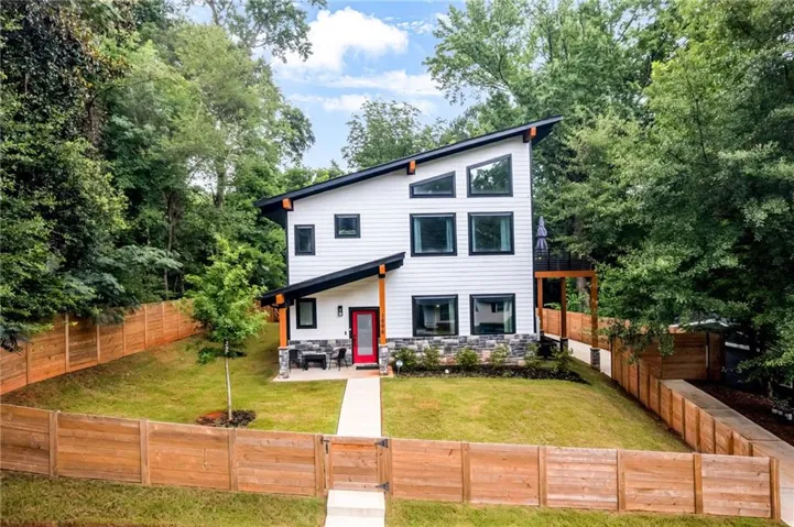 Contemporary exterior featuring white horizontal siding and a black-framed window arrangement