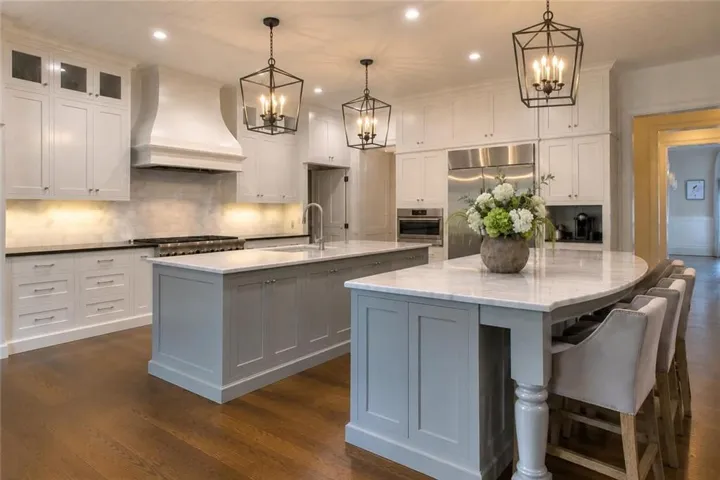 Gourmet kitchen featuring double Kitchen Islands, marble counter tops, marble backsplash, 2 dishwashers, thermador range, and a sub zero fridge.