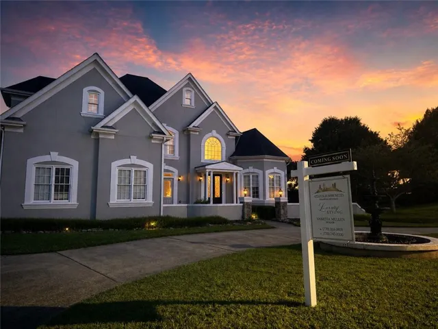 Stucco exterior residence featuring multiple gables and white trim accents