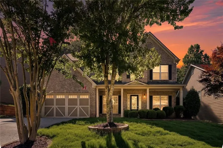 Two-story brick facade residence with a columned front porch and decorative front door