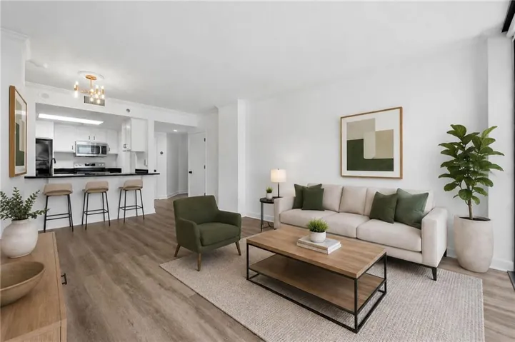 Open-concept living area featuring wood-finish flooring, white walls, and recessed lighting
