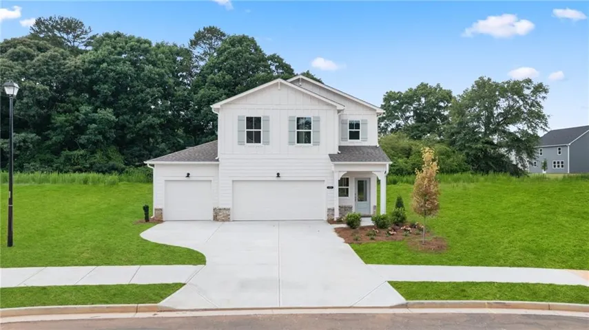 Contemporary two-story residence featuring white siding and gray window shutters