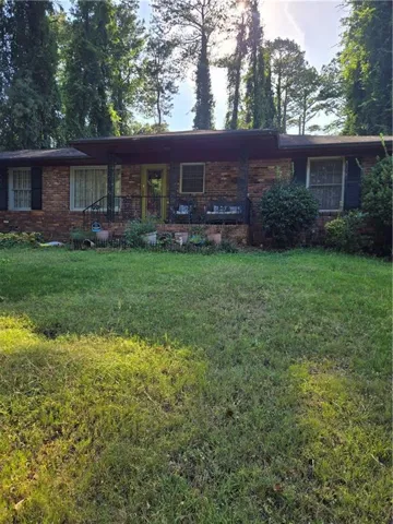 Brick exterior with dark shutters and a covered porch