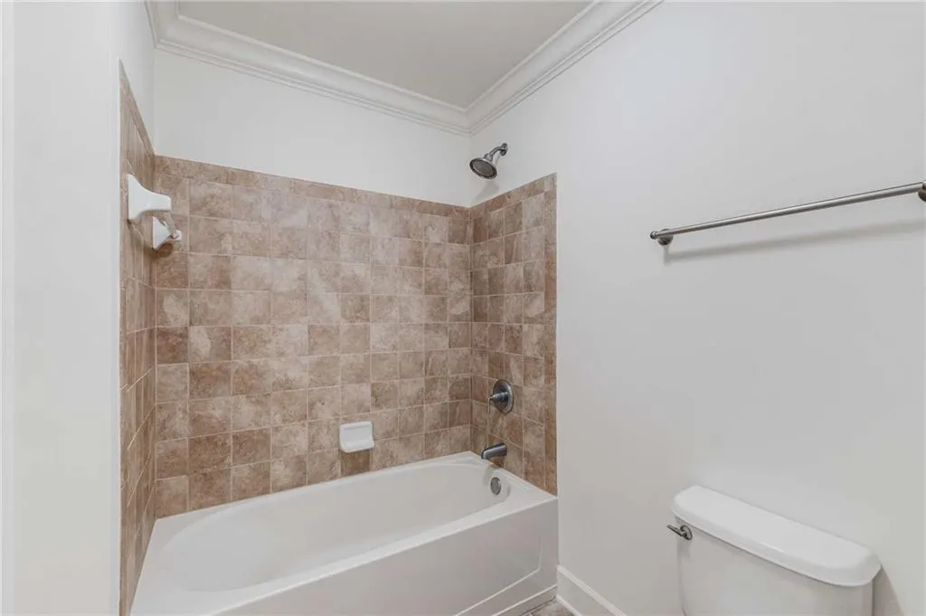 Tub shower with lovely neutral tilework.