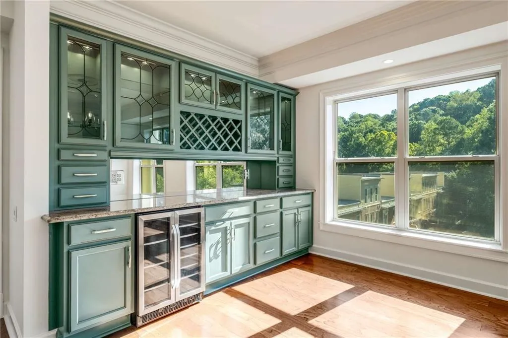 This custom designed piece even has glass shelves with lighting and under cabinet lighting, too! Notice your tree top views you can enjoy while making a cocktail!