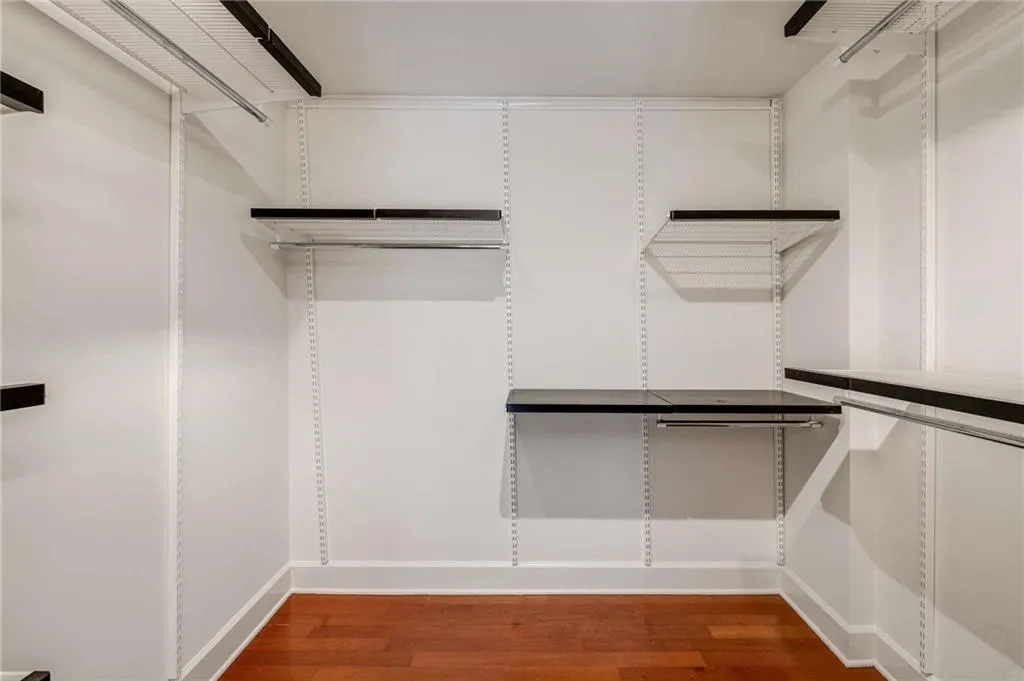 Owners walk in closet even has hardwoods and customized shelving system.