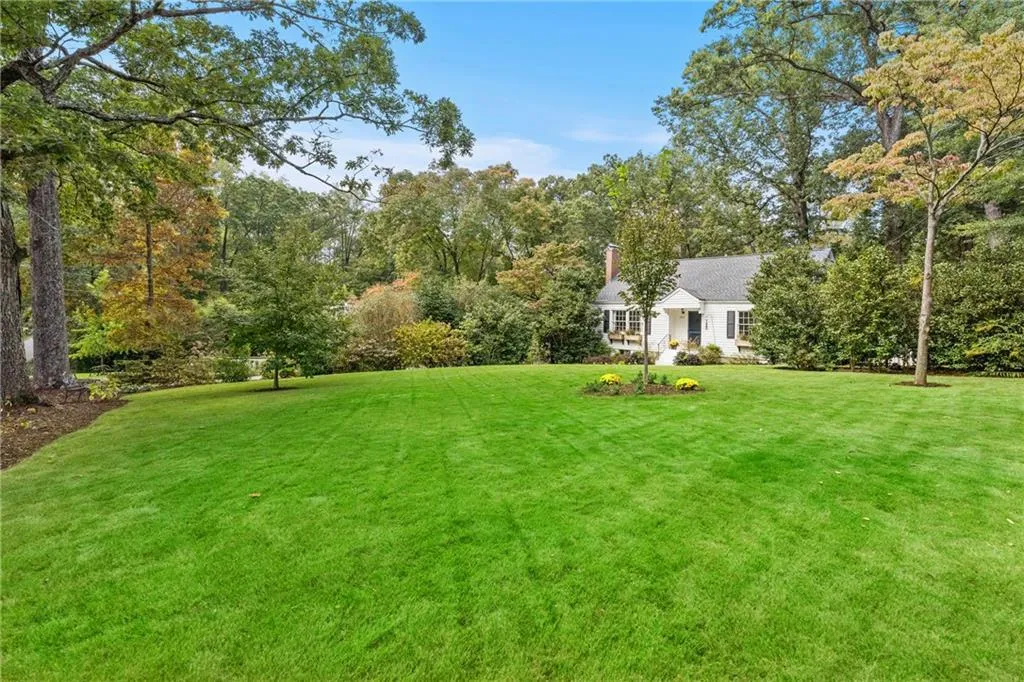 Lush landscaping and majestic trees frame this beautiful, oversized lot.