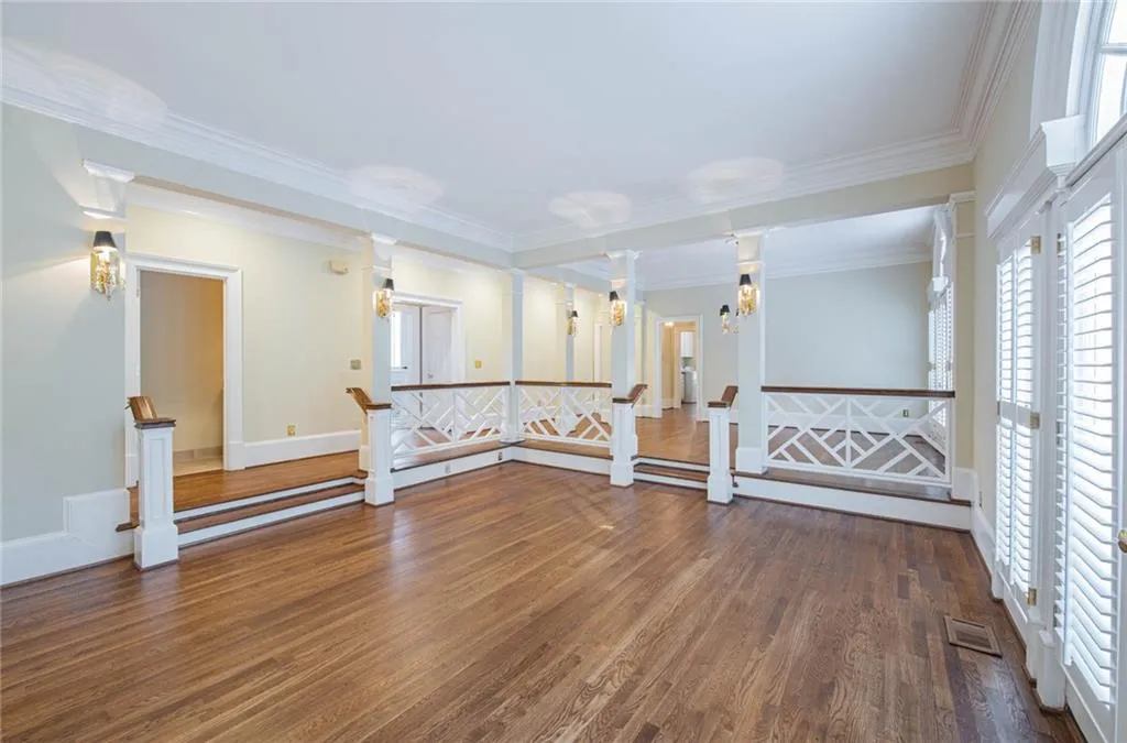 THIS GREAT ROOM FEATURES A BEAUTIFUL WALL OF WIDOWS, MARBLE FIREPLACE, BUILT-IN BOOKCASES, AND NEW EXTERIOR DOORS THAT OPEN TO THE DECK.