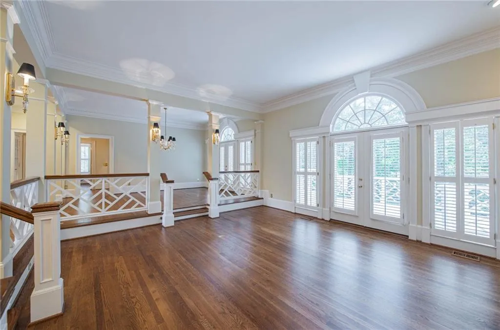 THIS GREAT ROOM FEATURES A BEAUTIFUL WALL OF WIDOWS, MARBLE FIREPLACE, BUILT-IN BOOKCASES, AND NEW EXTERIOR DOORS THAT OPEN TO THE DECK.