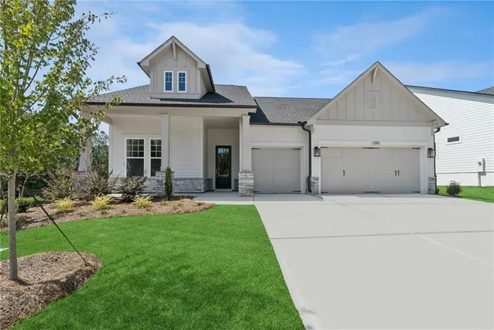 Contemporary home with a two-car garage, white siding, and stone accents