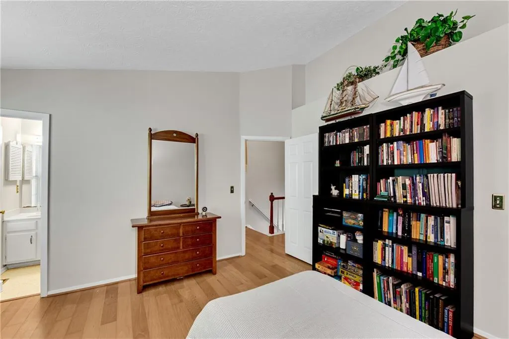 Bedroom with vaulted ceiling, light hardwood / wood-style flooring, ensuite bathroom, and a textured ceiling Bedroom with vaulted ceiling, light hardwood / wood-style flooring, ensuite bathroom, and a textured ceiling