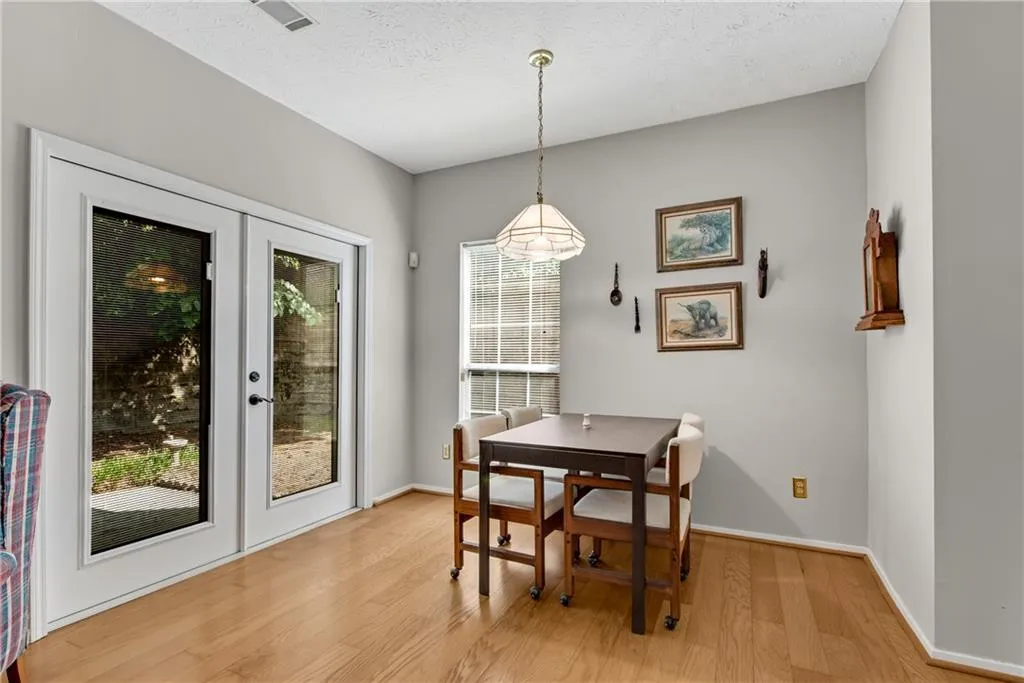 Dining area featuring a healthy amount of sunlight, french doors, light wood-type flooring, and a textured ceiling Dining area featuring a healthy amount of sunlight, french doors, light wood-type flooring, and a textured ceiling