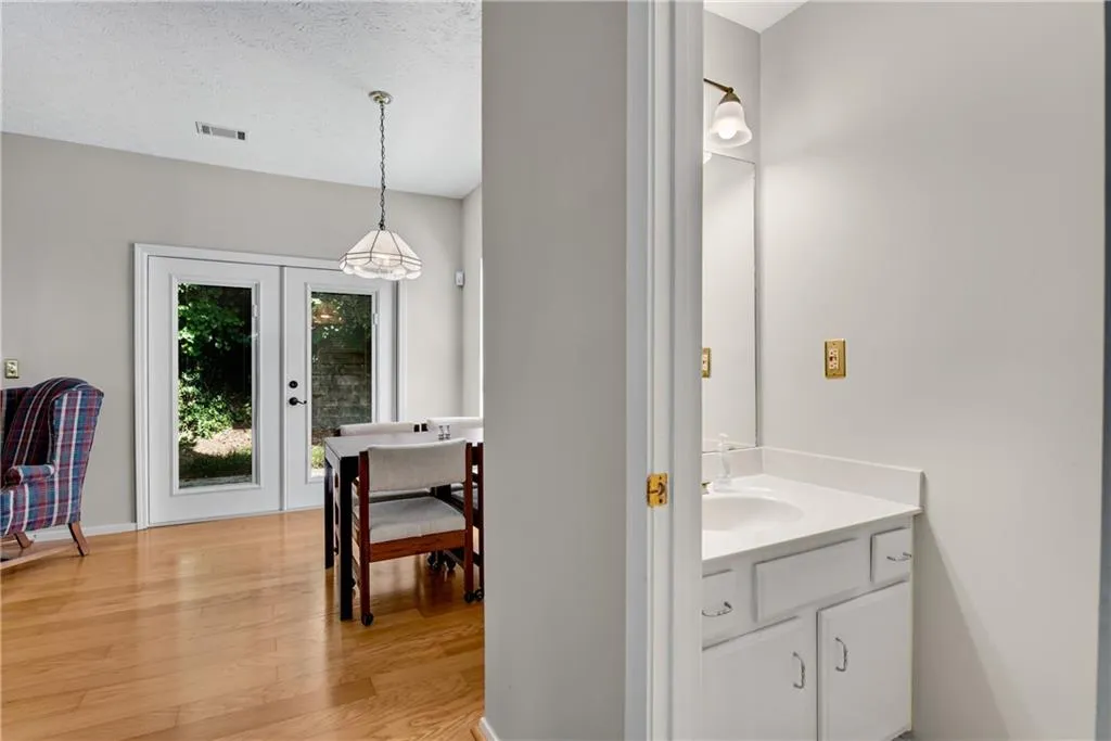 Bathroom with hardwood / wood-style flooring, french doors, vanity, and a textured ceiling Bathroom with hardwood / wood-style flooring, french doors, vanity, and a textured ceiling