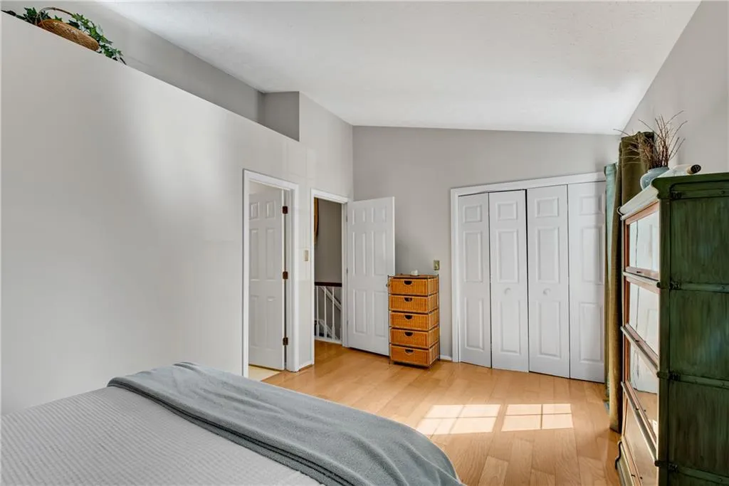 Bedroom featuring light hardwood / wood-style flooring, vaulted ceiling, and a closet Bedroom featuring light hardwood / wood-style flooring, vaulted ceiling, and a closet