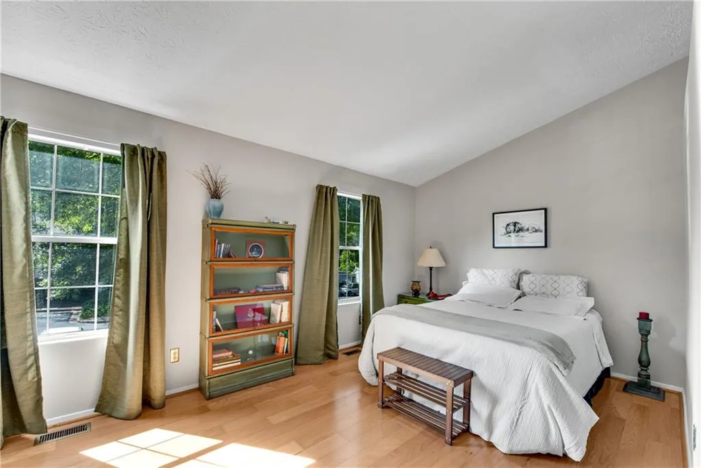 Bedroom with light hardwood / wood-style flooring and lofted ceiling Bedroom with light hardwood / wood-style flooring and lofted ceiling