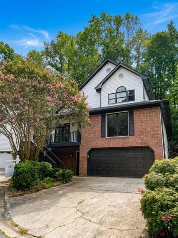 Brick and white siding exterior with an attached garage