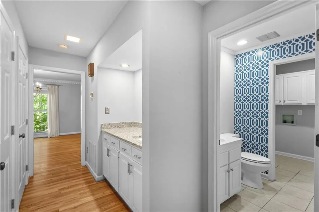 Hallway from front living room to dining/kitchen and keeping room.  Bar on right elevator on left Hallway from front living room to dining/kitchen and keeping room.  Bar on right elevator on left