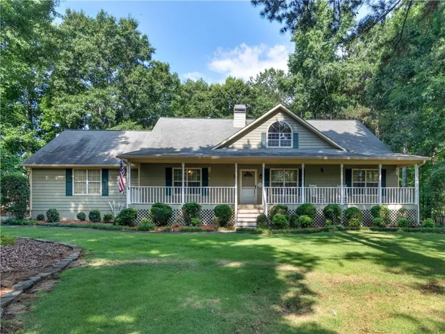 Craftsman-style home with an expansive front porch, white railings, and green shutters