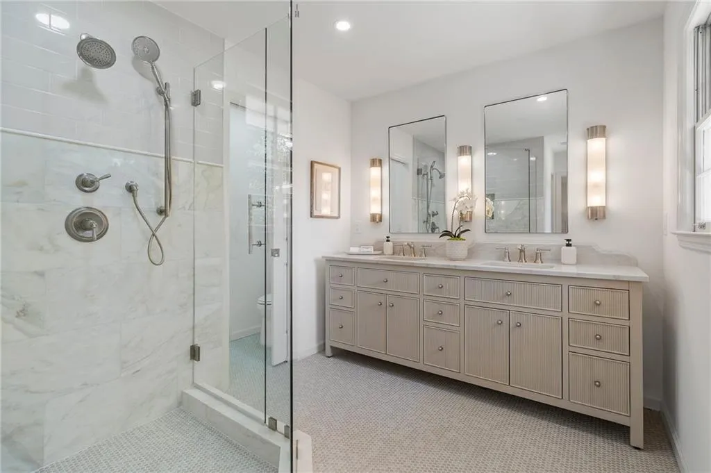 Primary bath features two sinks, water closet, and standing shower