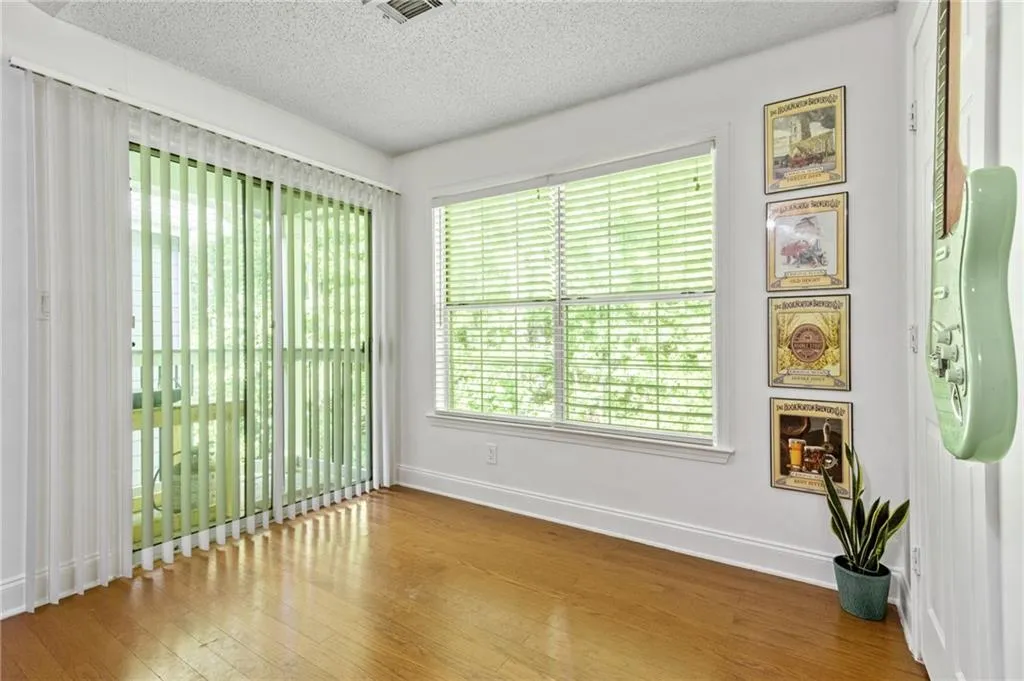 Empty room with hardwood / wood-style flooring and a textured ceiling