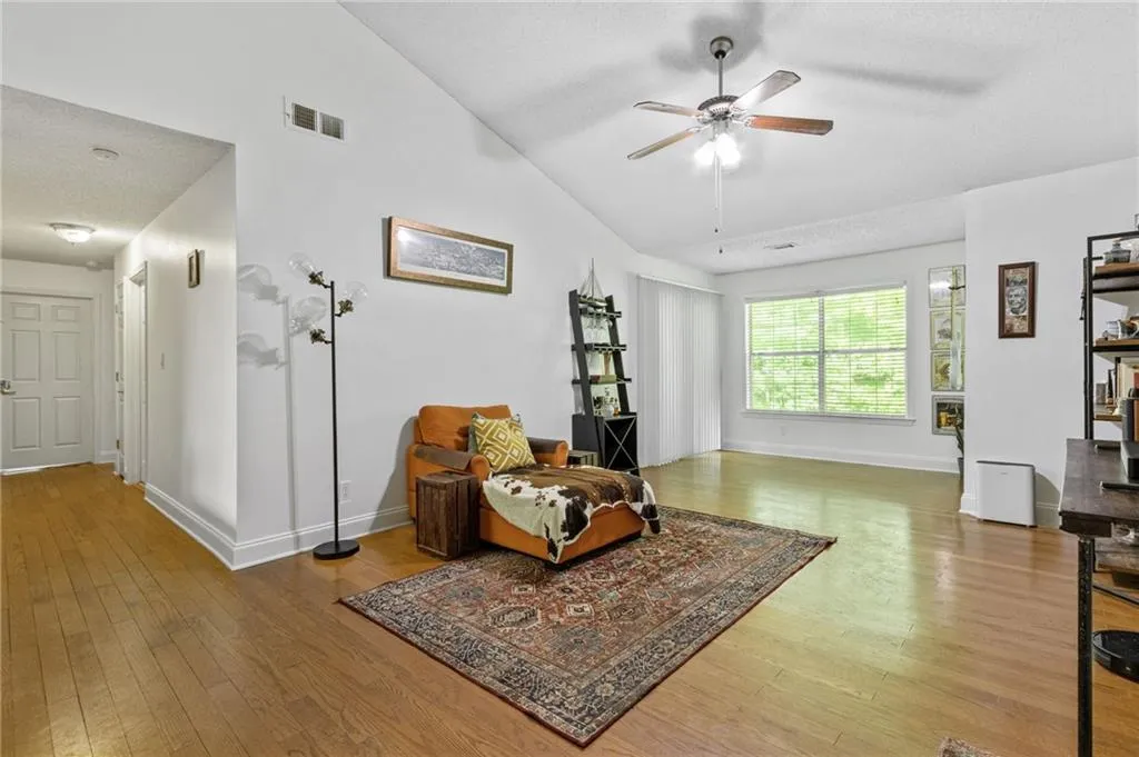 Sitting room featuring high vaulted ceiling, ceiling fan, and wood-type flooring
