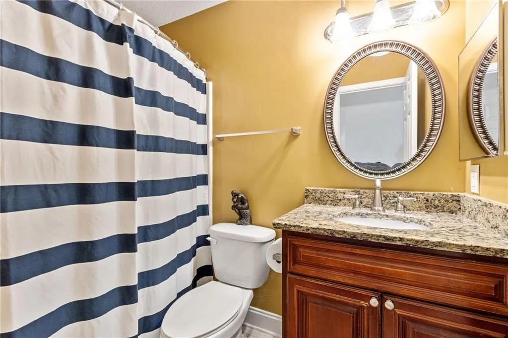 Bathroom featuring vanity, toilet, and a textured ceiling