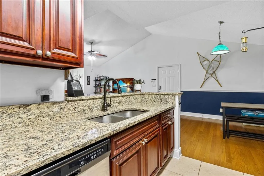 Kitchen featuring ceiling fan, stainless steel dishwasher, decorative light fixtures, light tile floors, and sink