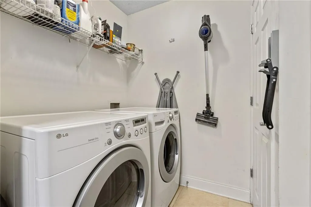 Laundry room featuring washing machine and dryer, hookup for a washing machine, and light tile floors