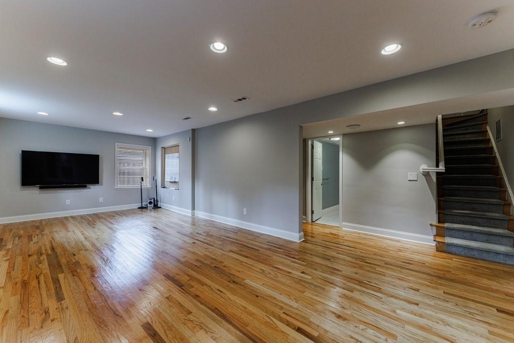 Large basement with recreation room and hardwood floors.