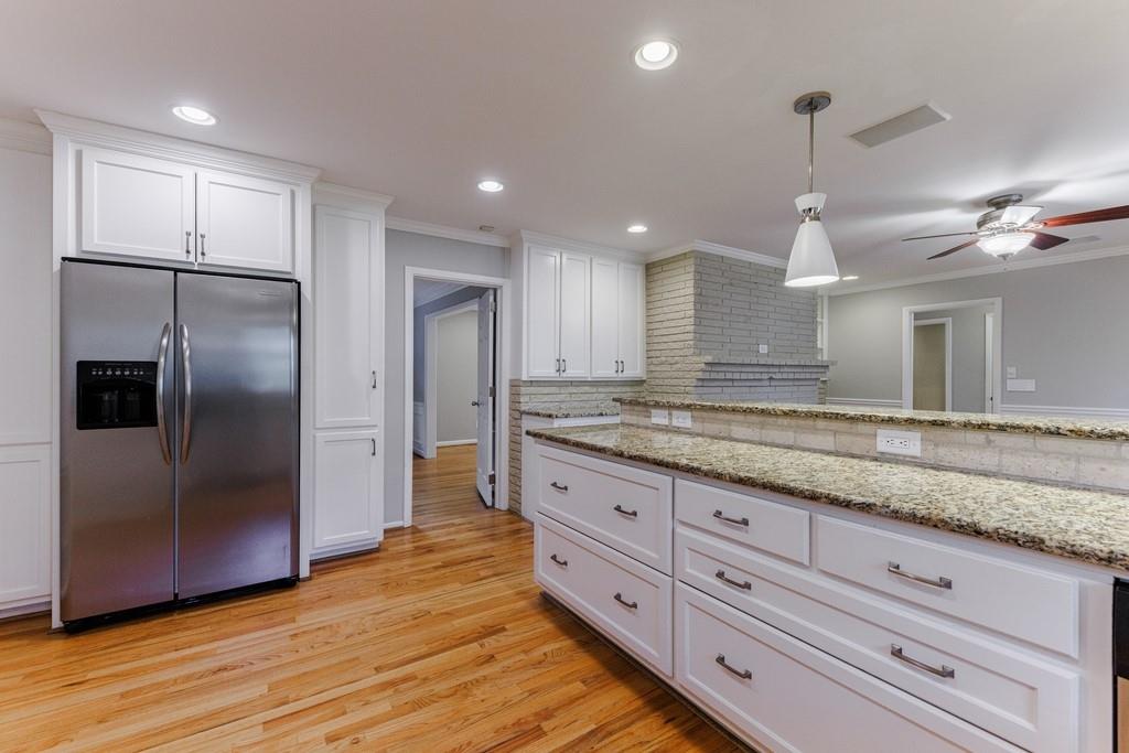 Stainless steel appliances and more cabinet storage flanking the refrigerator