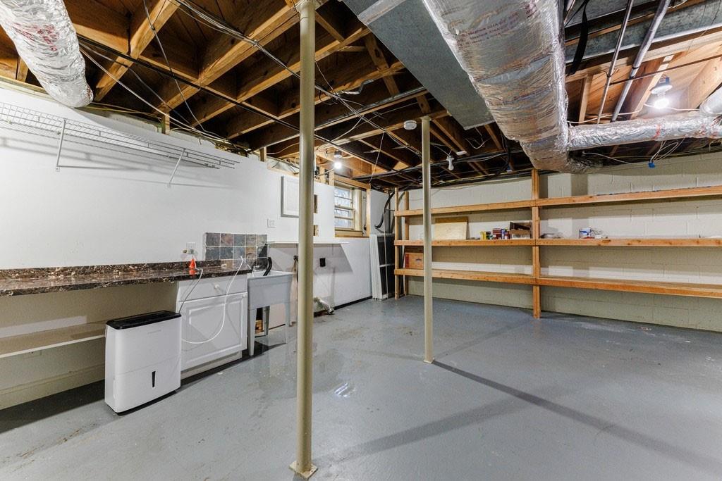 Large laundry room on the lower level with sink and lots of built-in storage shelving