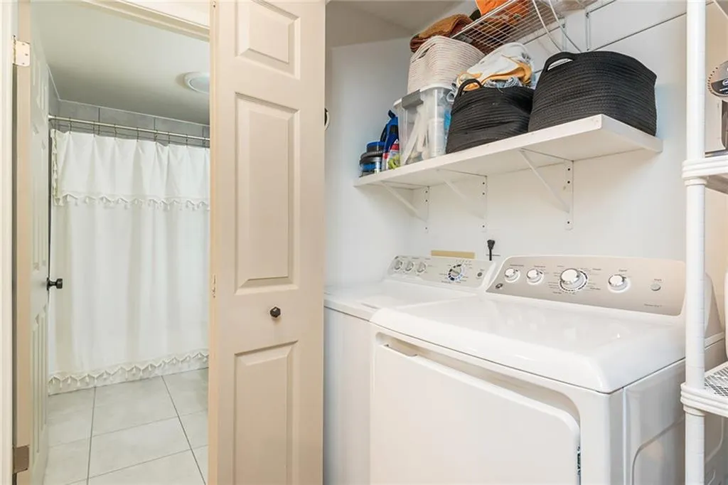 Laundry room featuring light tile patterned floors and washer and clothes dryer