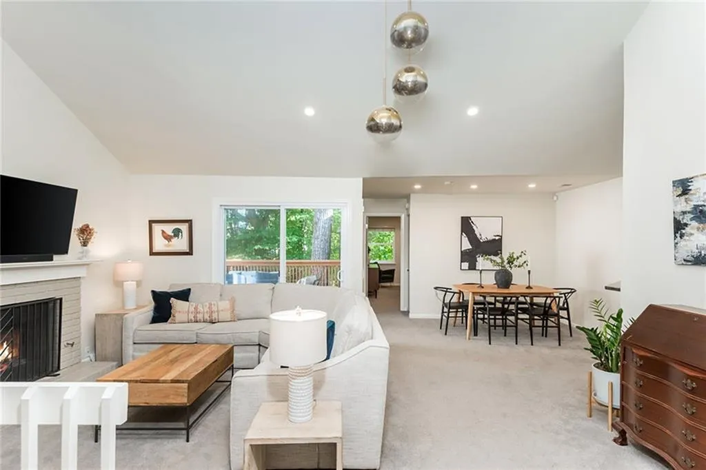 Carpeted living room with a brick fireplace