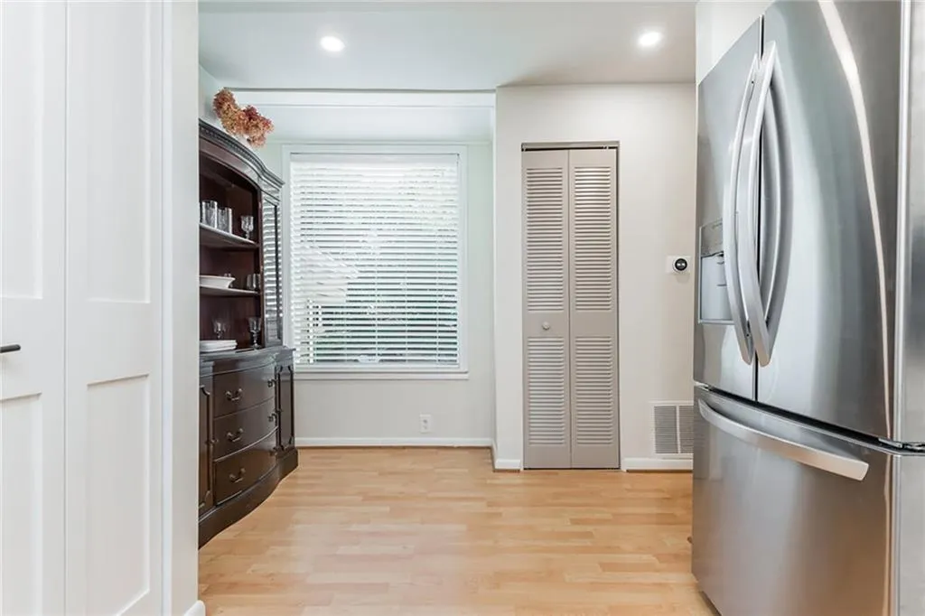 Kitchen featuring light hardwood / wood-style flooring and stainless steel fridge with ice dispenser