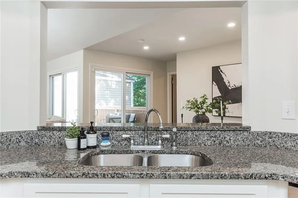 Kitchen with dark stone counters, sink, and white cabinetry
