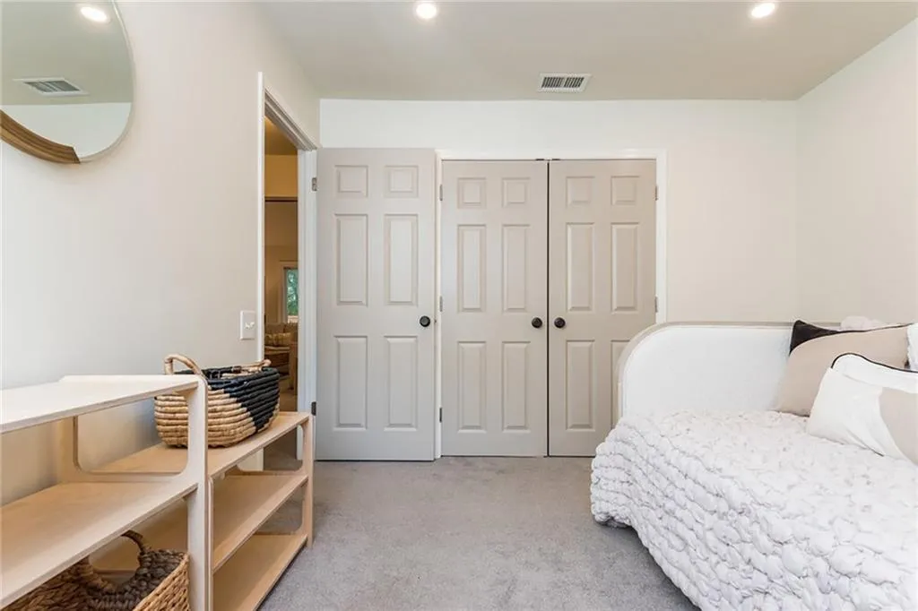 Bedroom with light carpet and a closet