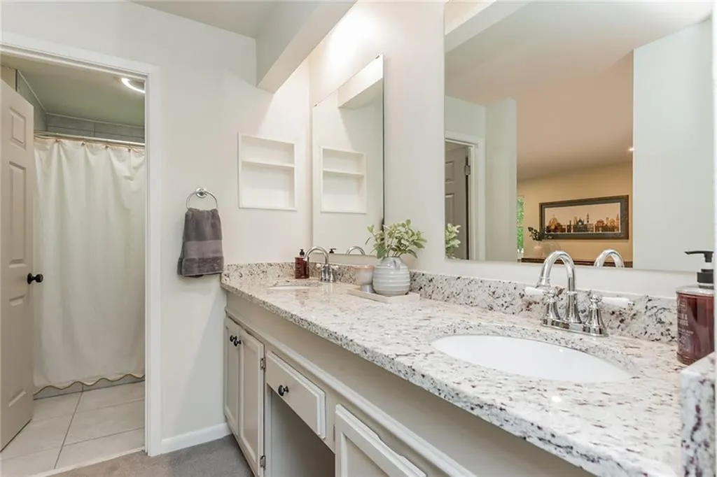 Bathroom featuring tile patterned floors, vanity, and a shower with curtain