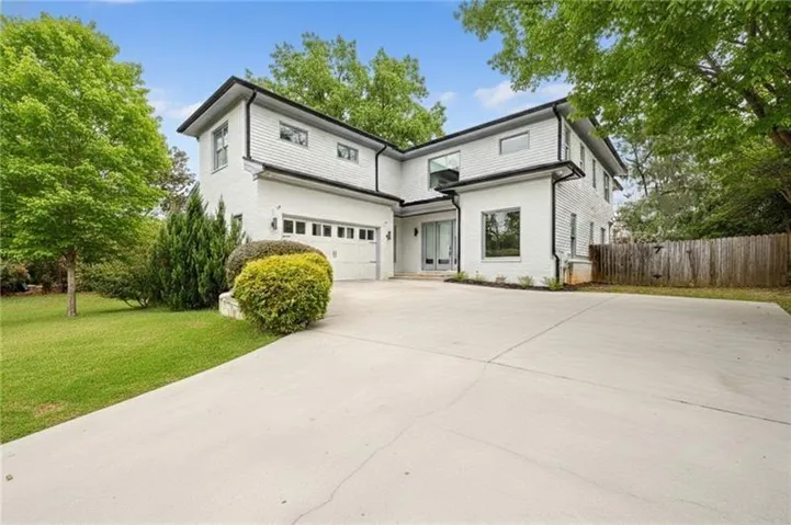 Contemporary two-story residence featuring a white brick exterior with black trim accents