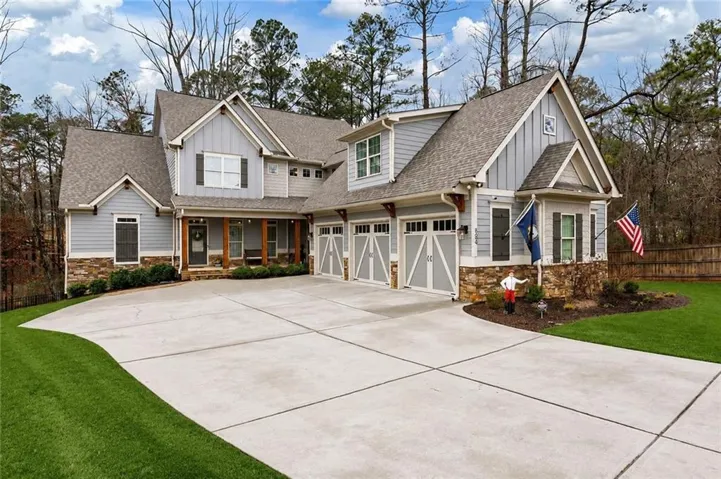 Craftsman-style exterior featuring light blue siding, stone veneer accents, and a covered front porch with wood columns