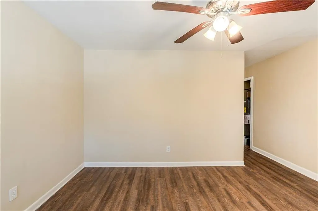 Unfurnished room with ceiling fan and dark hardwood / wood-style flooring