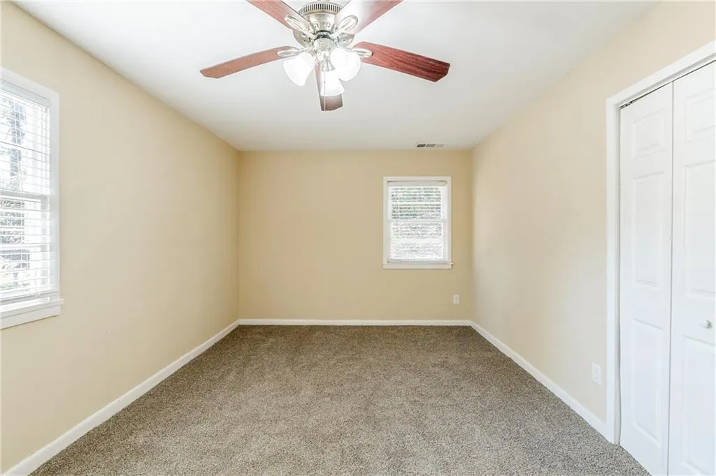 Unfurnished bedroom featuring carpet floors, a closet, and ceiling fan